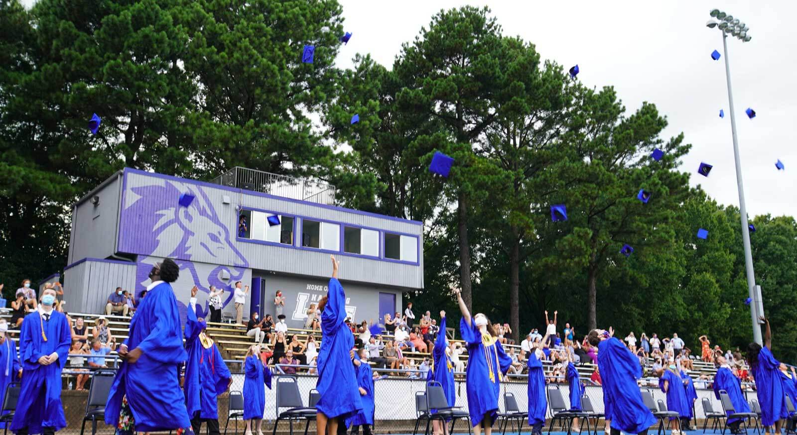 people at graduation throwing their caps in the air