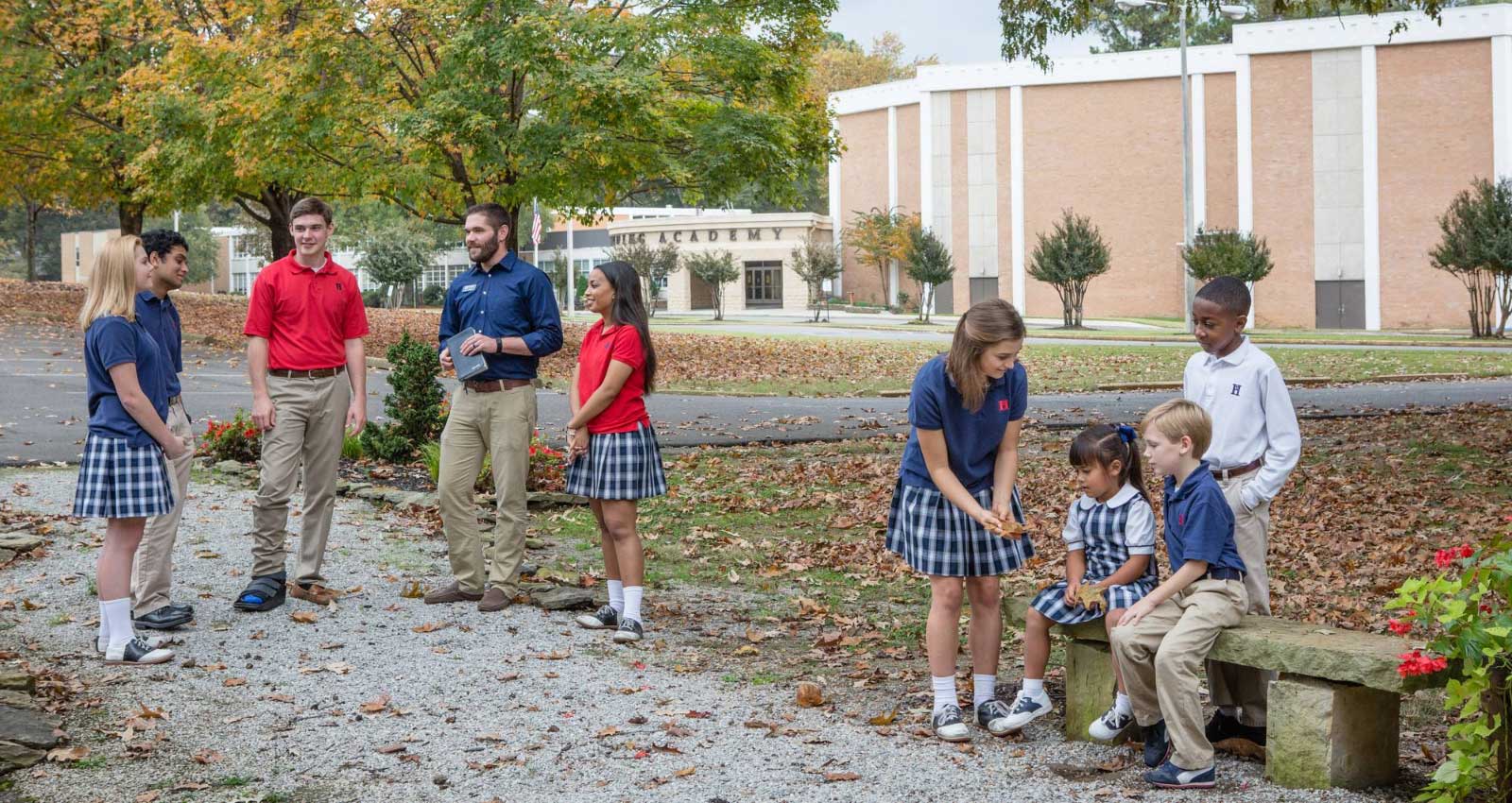 people standing outside of a school in uniforms