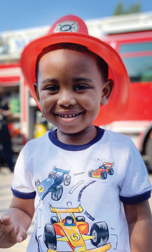 little boy wearing fireman hat